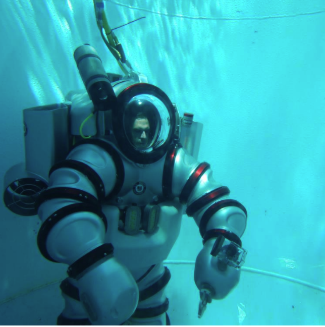 Under water diver in a big suit, deep down in the ocean
